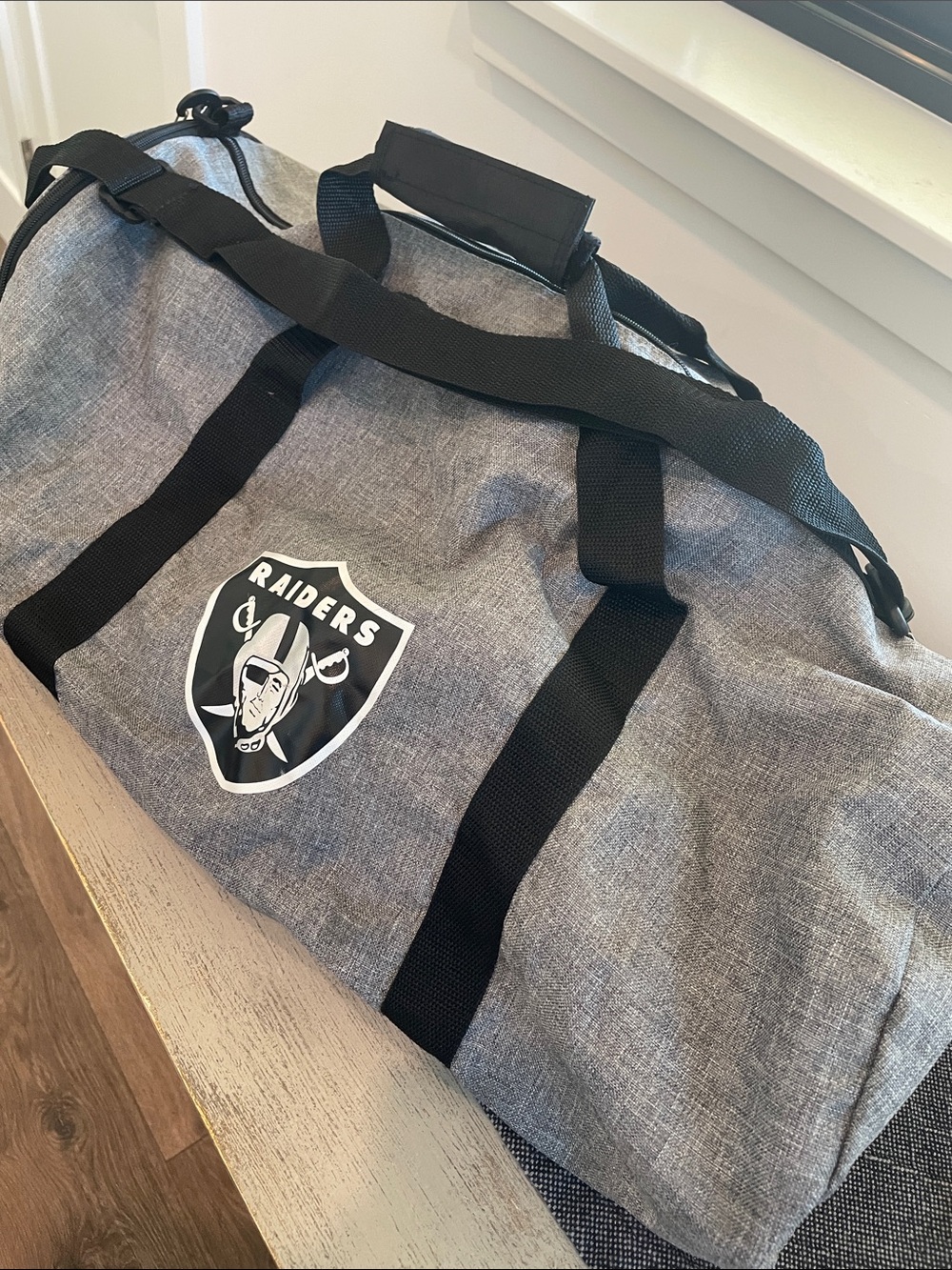 Northwest Gray Duffel Bag with Black Straps and Raiders Logo